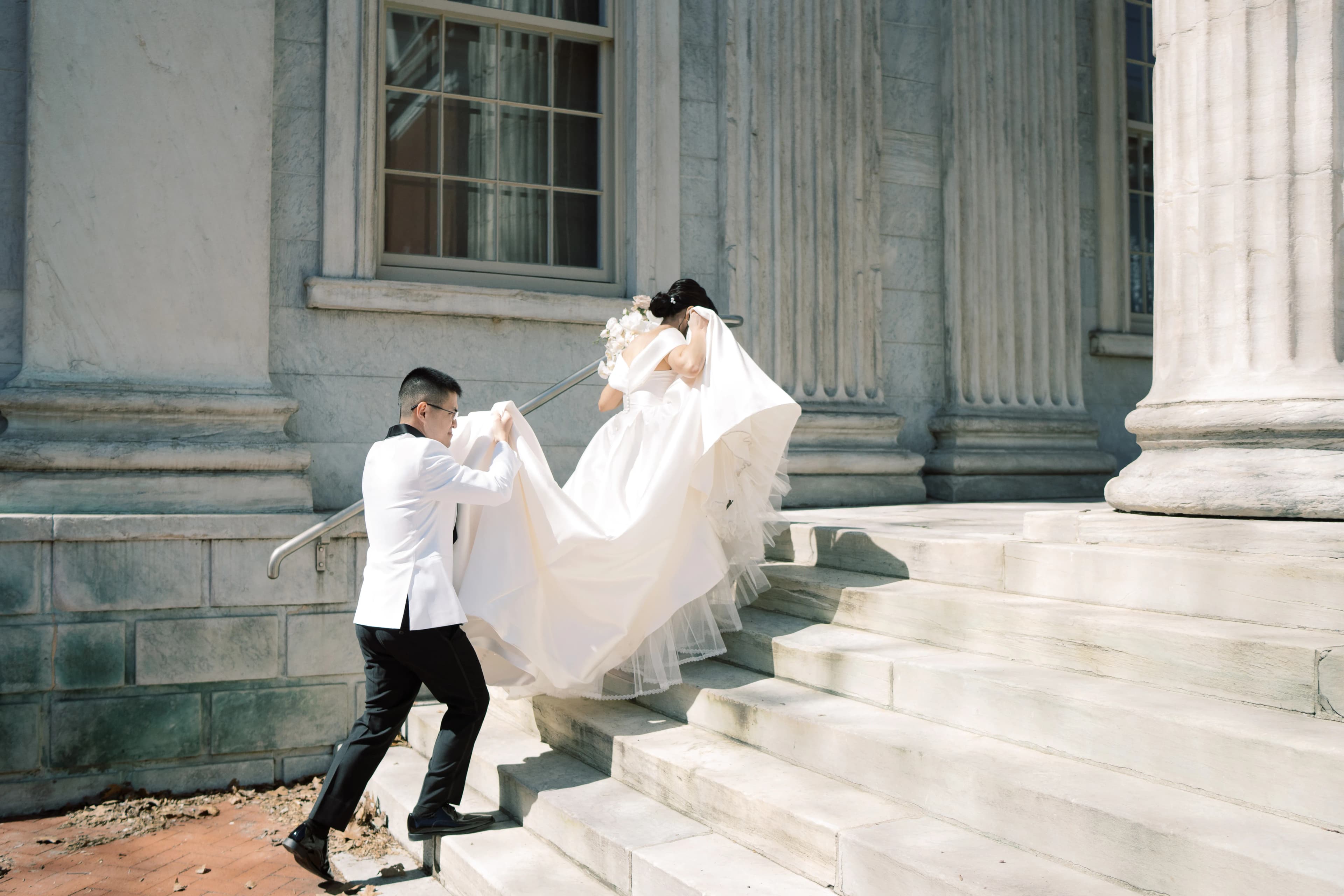 A happy bride and groom walking up stone steps